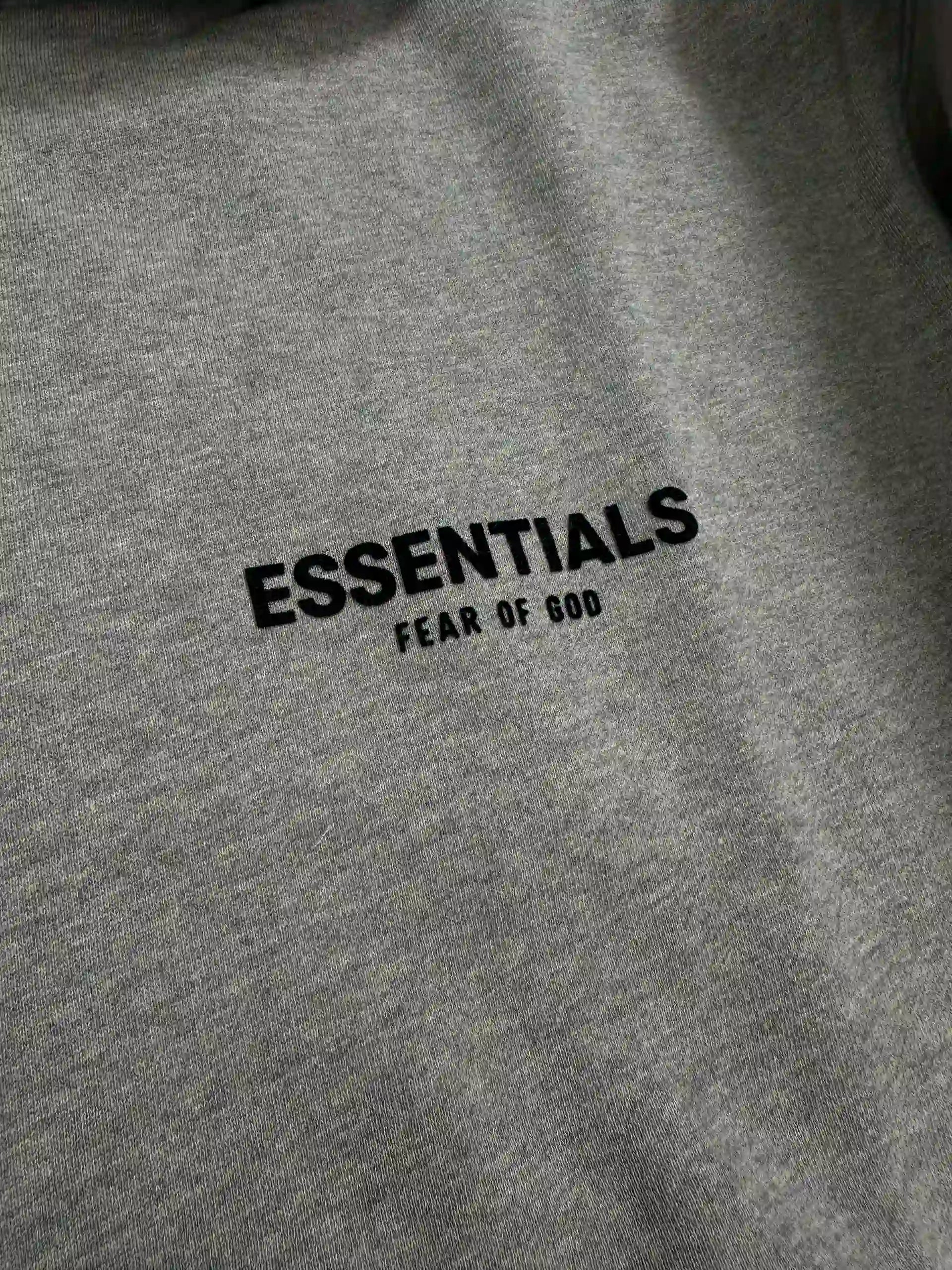 Front chest logo detail of ESSENTIALS fleece hoodie, dark oatmeal color, relaxed oversized fit streetwear sweatshirt