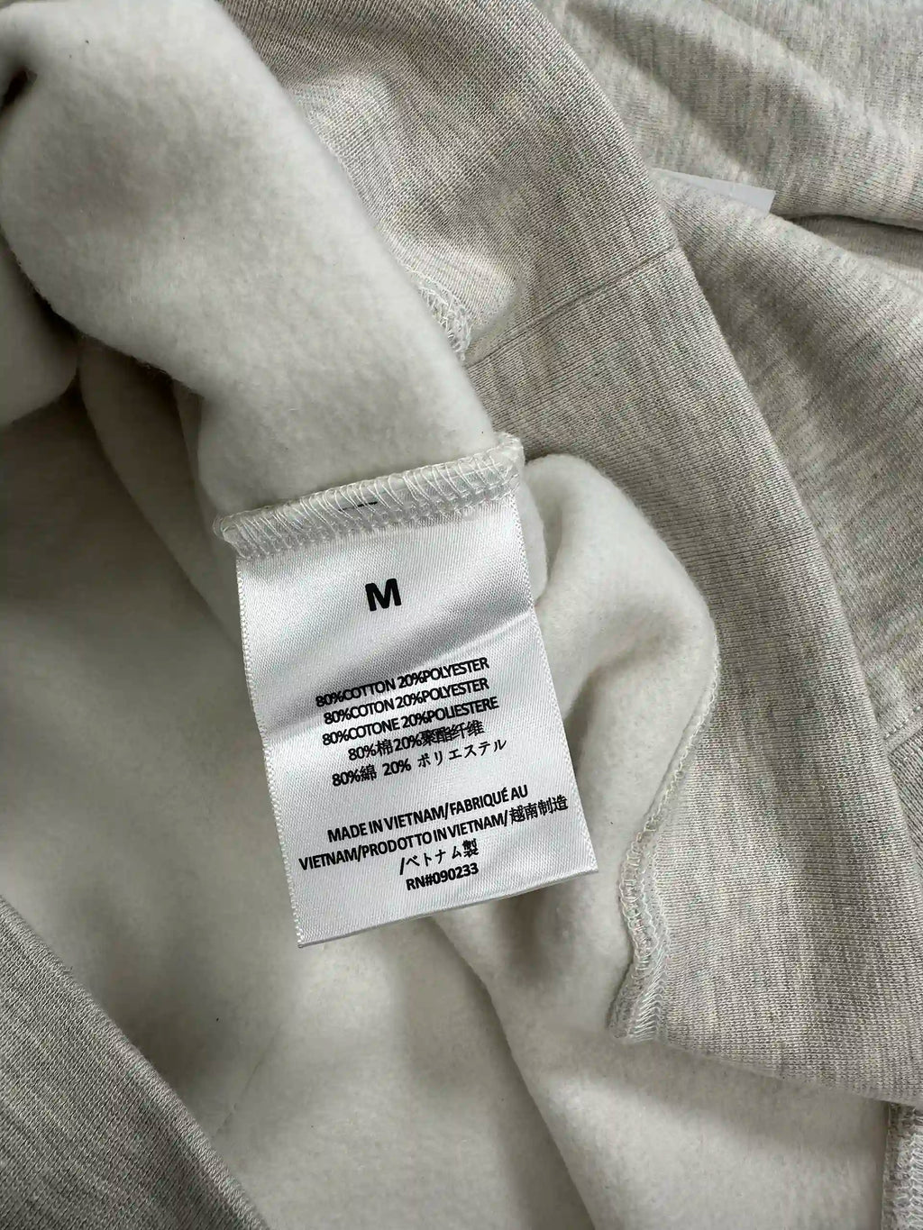 Interior care label showing fabric composition and size on fleece hoodie