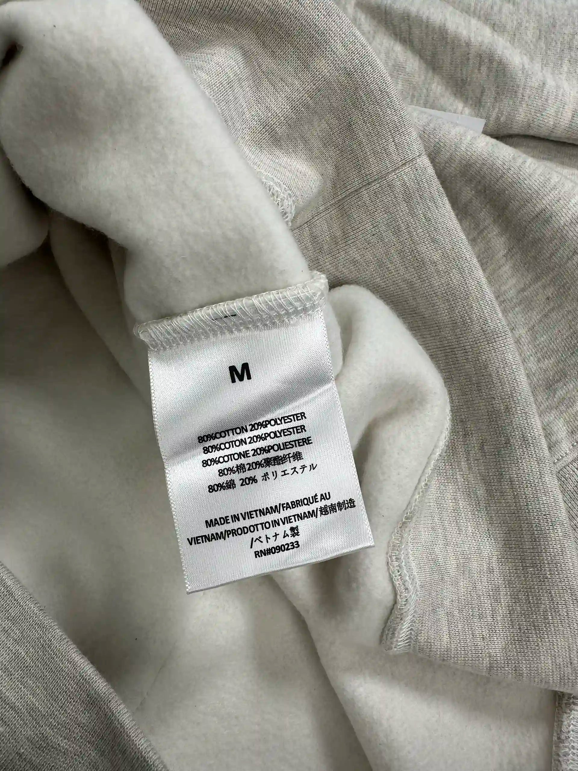 Interior care label showing fabric composition and size on fleece hoodie