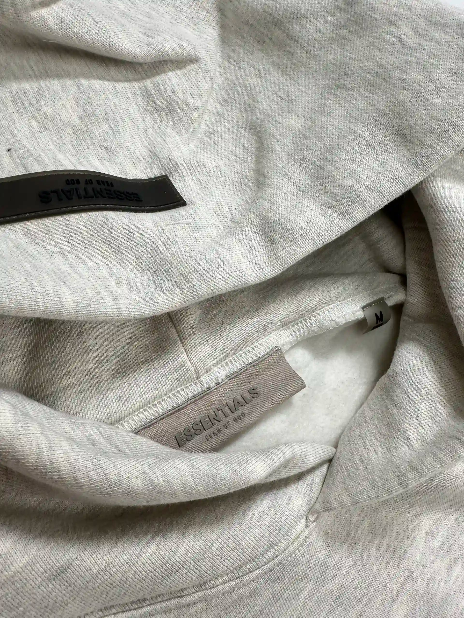 ESSENTIALS 2022 hoodie neck tag detail on Light Oatmeal fleece
