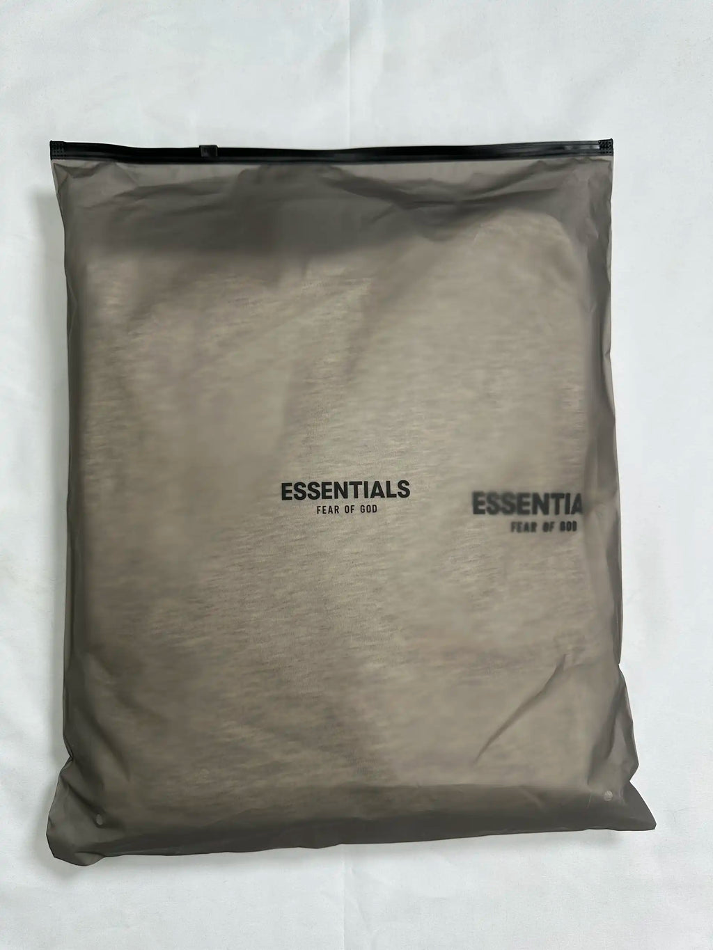 ESSENTIALS 2022 hoodie in light oatmeal color shown in original zip packaging