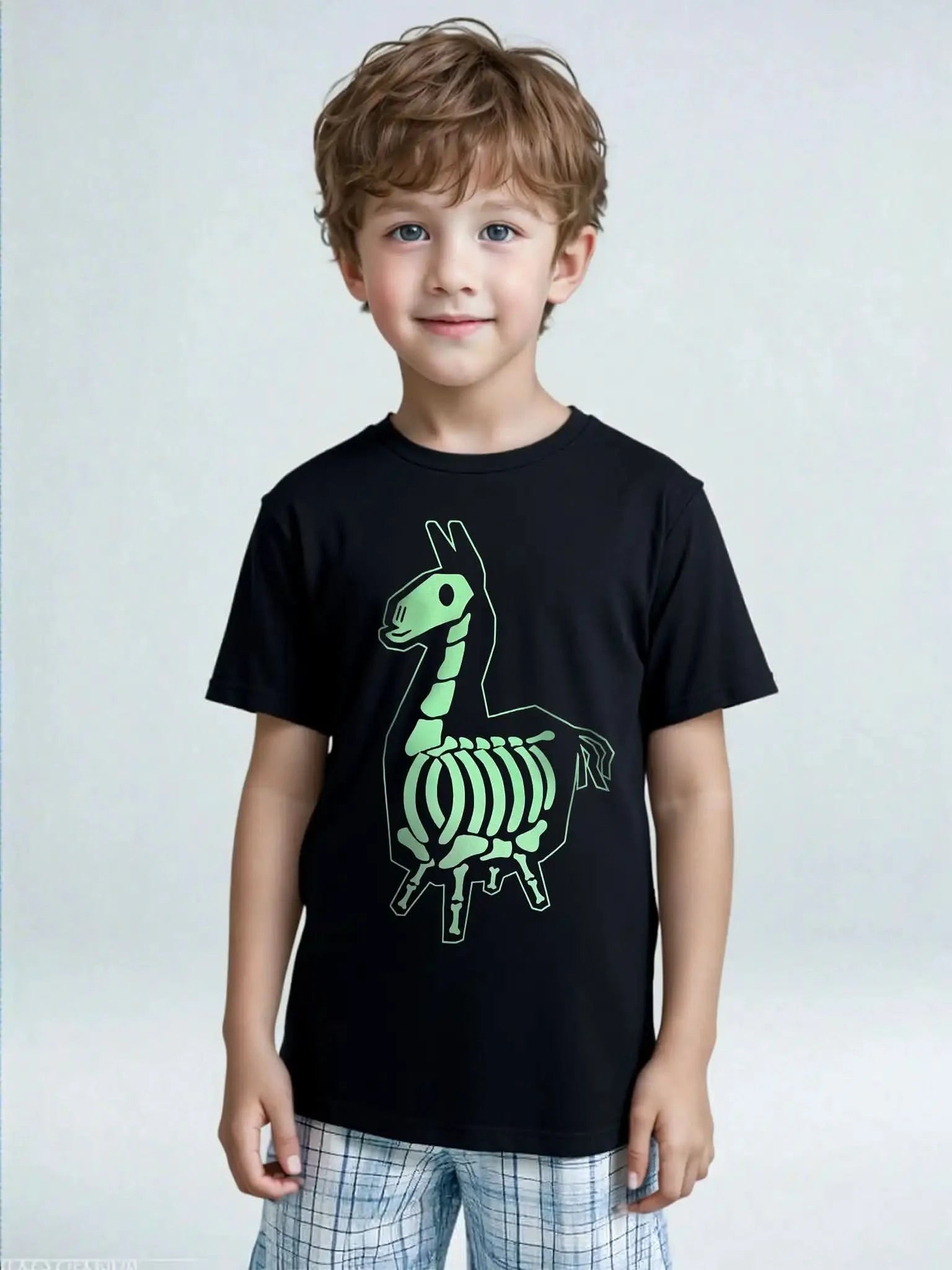 Young boy wearing a black Fortnite skeleton llama T-shirt and plaid shorts, unisex kids fit with green graphic print.