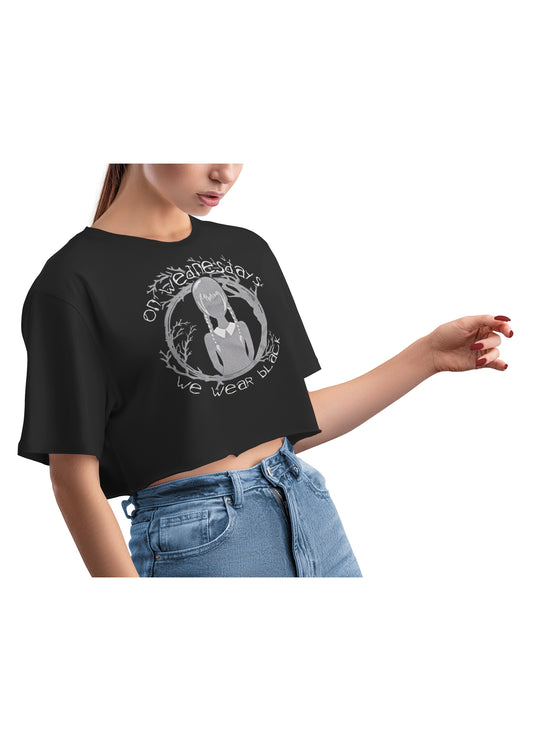Woman wearing black Wednesday Addams inspired graphic crop top, side view