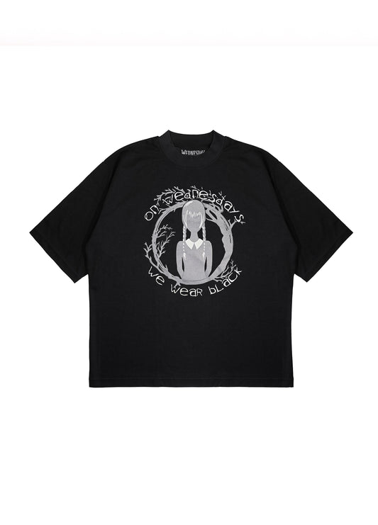 Flatlay of black graphic t-shirt with 'On Wednesdays We Wear Black' text and Wednesday Addams silhouette